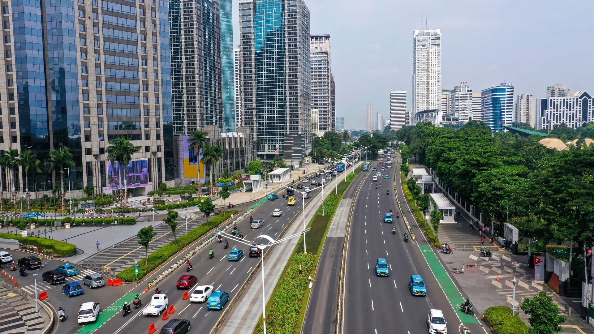 Bilden visar en väg i Jakarta och höga hus.