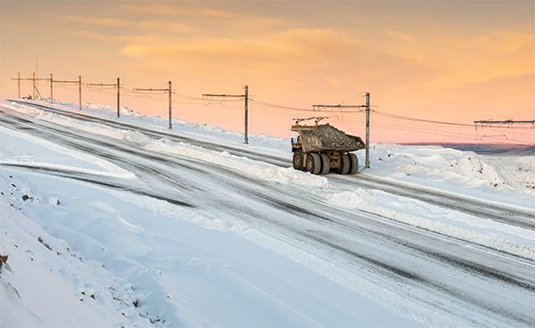 Electric trolley line and mine truck in snowy landscape